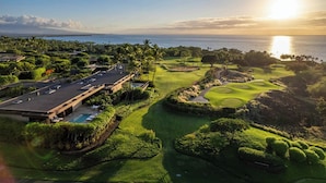 A golf course with a clubhouse, a swimming pool, and a view of the ocean. - Villas at Mauna Kea 14 Two Bedroom (Kamuela)