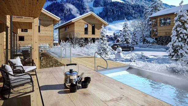 Eine Holzhütte mit Pool, umgeben von schneebedeckten Bäumen und einem Berg im Hintergrund.