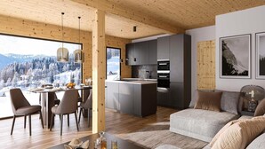 Ein modernes Interieur mit Holzboden, einem Essbereich mit Blick auf eine verschneite Landschaft, einer Küche mit grauen Schränken und einem Wohnbereich mit Sofa und Kissen.