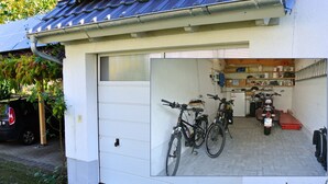 Eine Garage mit Fahrrädern und einem Motorrad darin.