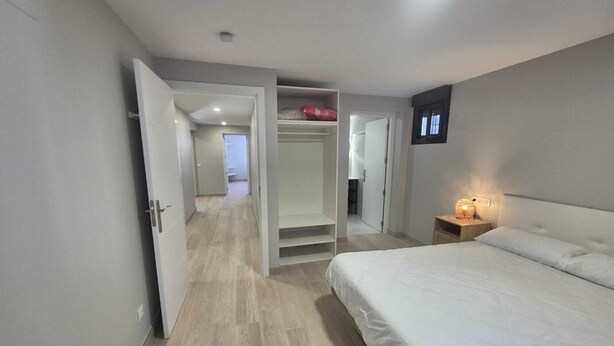 Ein Schlafzimmer mit Bett, Nachttisch und Kleiderschrank.