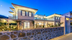A multi-story building with a stone facade, large windows, and a well-lit entrance. - Louise'in Konağı (Datça)