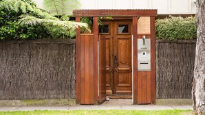 A wooden entrance with a door labeled "1 STREET" and a mailbox. - Pet Friendly - Bayside Oasis in Highett (Highett)