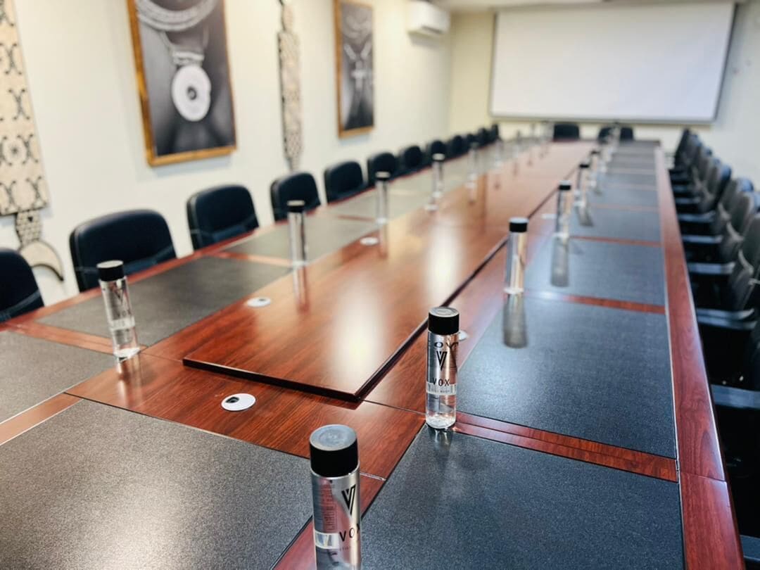 A conference room with a long table, chairs, and water bottles.