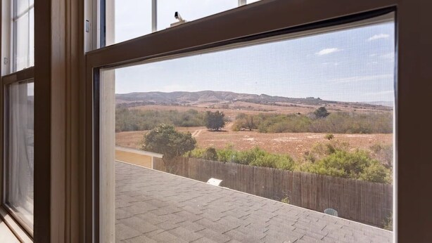 A view through a window with a view of a hilly landscape and a wooden fence. - Classic 20th Century Architecture, Huge space for large families (Santa Maria)