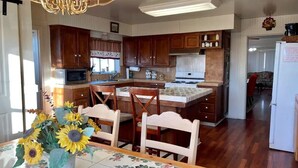 A kitchen with wooden cabinets, a dining table with chairs, and a chandelier. - Classic 20th Century Architecture, Huge space for large families (Santa Maria)