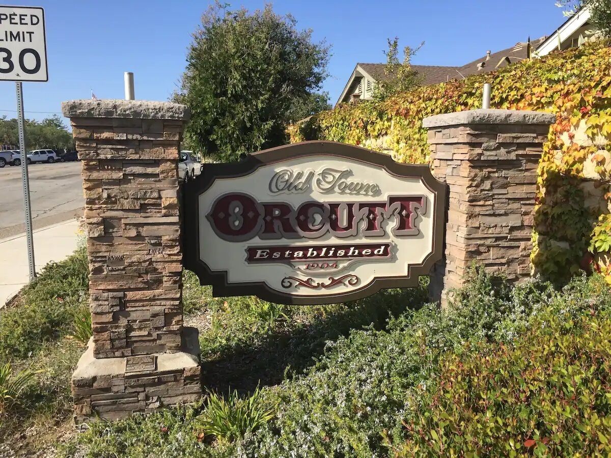 A sign for Old Town Broutt with a speed limit sign nearby.
