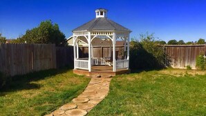 A gazebo with a stone pathway leading to it, surrounded by a wooden fence and grass. - Classic 20th Century Architecture, Huge space for large families (Santa Maria)
