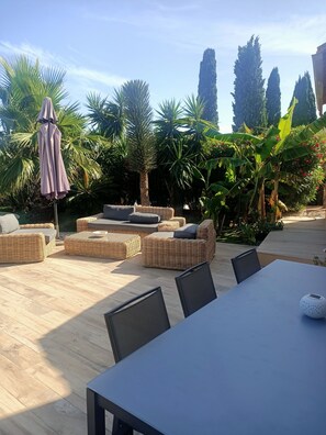 Relax and socialize in this serene outdoor space surrounded by lush greenery and comfortable seating.