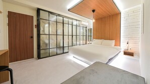 Un dormitorio moderno con una cama grande, un ventanal corredizo y techo de madera.