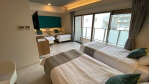 Une chambre d’hôtel avec deux lits, un bureau et une grande fenêtre donnant sur des immeubles.