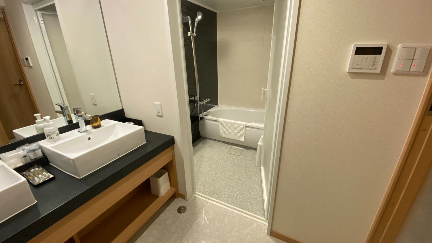 Une salle de bain moderne avec un lavabo blanc, un miroir et une douche.