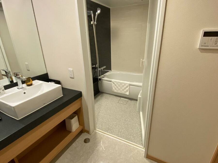 Une salle de bain moderne avec un lavabo blanc, un miroir et une douche.