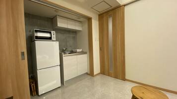 A compact kitchen with a refrigerator, microwave, and sink.