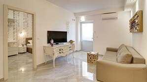 A modern living room with a flat-screen TV, a beige sofa, and a decorative wall piece. - Villa Vanda (Dubrovnik)