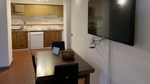 Eine moderne Küche mit Holzausstattung, einem eingebauten Geschirrspüler und einem Essbereich mit Tisch und Stühlen.