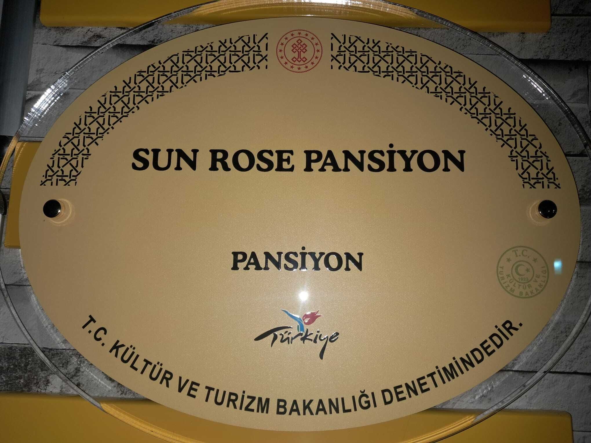 A circular plaque with inscriptions and a logo, mounted on a wall.