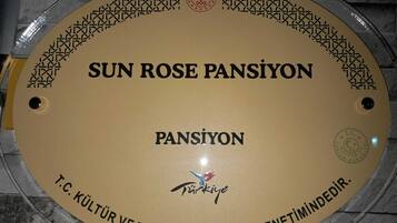 A circular plaque with inscriptions and a logo, mounted on a wall.