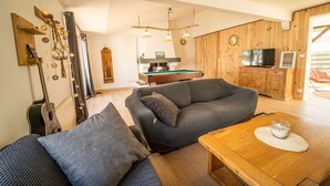 A cozy living room with a sofa, a coffee table, and a television. - Oleron Surf House (Dolus-d'Oléron)