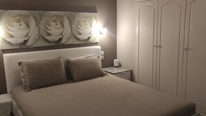 A bedroom with a bed, two bedside tables, a nightstand, a wall-mounted light, and a wardrobe. - Gorgeous 3 bedrooms Apartment in Pilio (South Pelion)