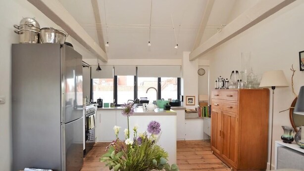 A modern kitchen with a central island, stainless steel appliances, and a wooden cabinet. - Historic grade II listed Townhouse (Norwich)