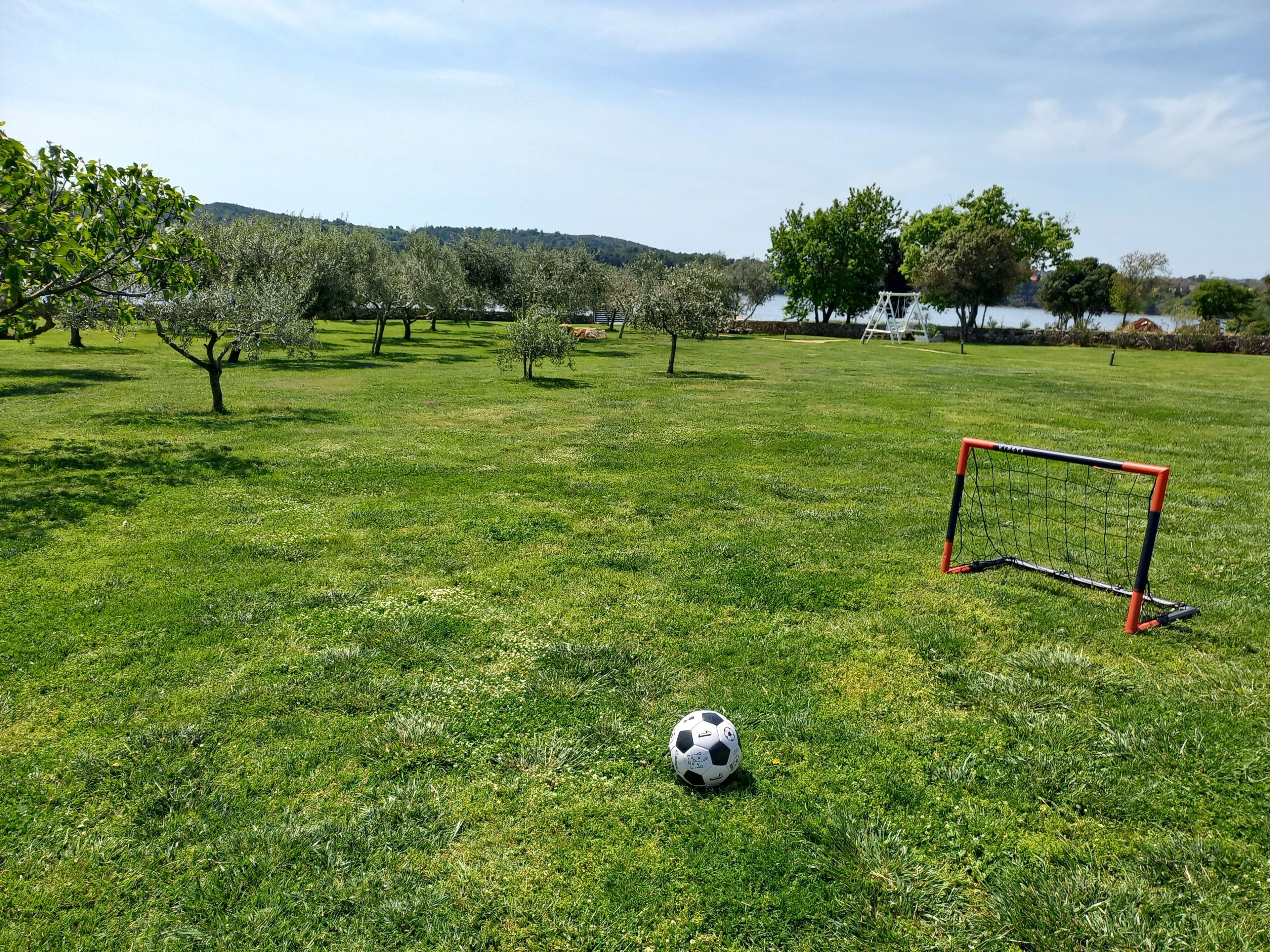 A soccer field with a goalpost and a soccer ball.