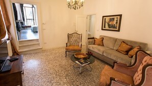 A living room with a sofa, armchairs, a coffee table, and a chandelier. - Ca' Nal Apartments, Corte Grimani Inn - BRAGOZZO (Venezia)