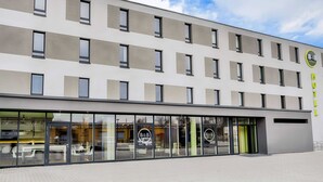 A modern hotel building with a flat facade, large windows, and a logo on the side. - B&B Hotel Kehl (Kehl)