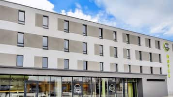 Un moderno edificio de hotel con fachada plana, amplias ventanas y un logotipo en el lateral.