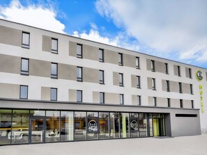 A modern hotel building with a flat facade, large windows, and a logo on the side. - B&B Hotel Kehl (Kehl)