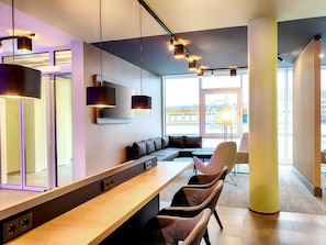 A modern hotel lobby with a long reception desk, comfortable seating, large windows, and contemporary lighting fixtures. - B&B Hotel Kehl (Kehl)