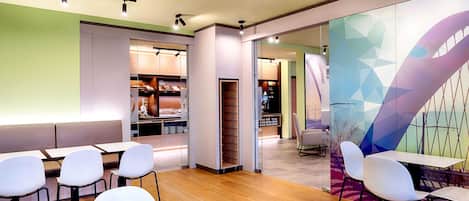 A modern interior with a seating area, a glass partition, and a colorful mural.