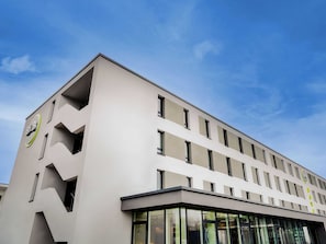 A modern building with a flat facade, multiple windows, and a prominent logo on the side. - B&B Hotel Kehl (Kehl)