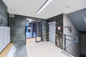 Ein modernes Interieur mit Glastür, Treppe und Marmorwand.