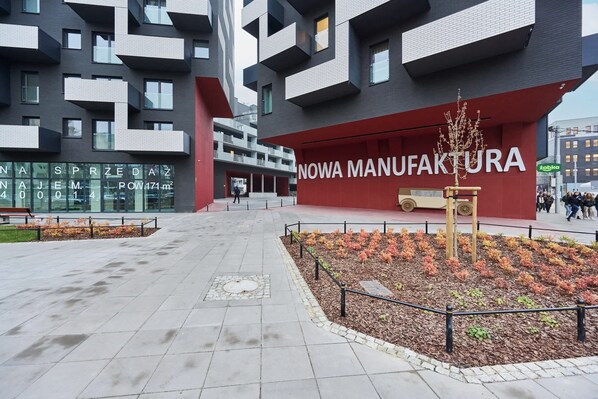 Un edificio moderno con fachada roja y el texto 'NOWA MANUFAKTURA'.
