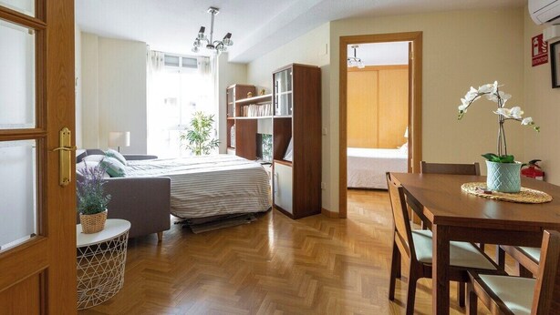 A compact living space with a bed, a dining table, and a bookshelf. - Vivodomo | Free parking, cozy, bright & central (Madrid)
