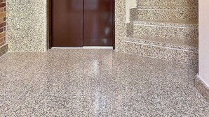 An elevator with a no-smoking sign, a stairwell with granite steps, and a door with a green emergency exit sign. - Vivodomo | New, super location, optional parking (Madrid)