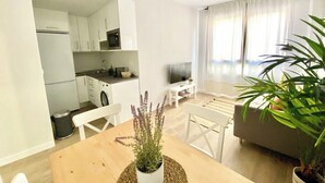 A modern apartment with a kitchen, dining area, and living room. - Vivodomo | New, super location, optional parking (Madrid)