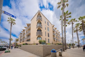 Un hotel de varios pisos con balcones, palmeras y una señal de calle que dice "Ocean BLVD 4500".