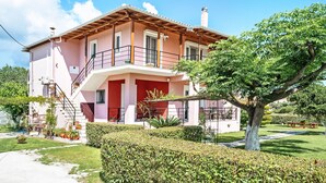Une maison à deux étages avec un balcon, un escalier et un jardin.