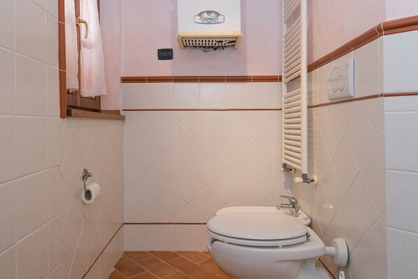 A small bathroom with a toilet, sink, and towel rack.