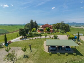 A house with a red roof, surrounded by green fields and trees. - Apartment "Oleandro" with Shared Garden & Wi-Fi (Santa Luce)