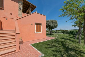 Un bâtiment à la façade rouge, doté d’un escalier et d’une pelouse bien entretenue.