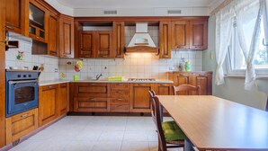 Una cucina con mobili in legno, un fornello, un lavandino e un tavolo da pranzo.