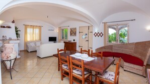 Uma sala ampla com mesa de jantar, sofá e área de cozinha.