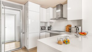 A modern kitchen with white cabinets, a stainless steel range hood, a microwave, and a kettle. - Villa "Casa Imjo Groundfloor" with Private Pool, Private Terraces & Air Conditioning (Orihuela Costa)