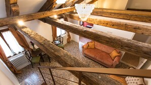 Un intérieur rustique avec des poutres apparentes, un canapé confortable et un radiateur.