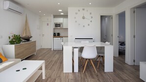 A modern kitchen with white cabinetry, a microwave, and a built-in clock. - Apartment with pool and parking. Ground floor with garden (Palafrugell)