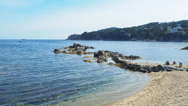 A beach with clear water, rocky outcrops, and a hillside with buildings. - Apartment with pool and parking. Ground floor with garden (Palafrugell)