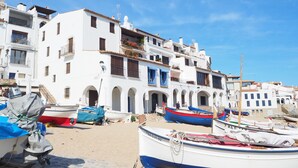 A coastal town with white buildings, blue balconies, and boats on the sand. - Apartment with pool and parking. Ground floor with garden (Palafrugell)